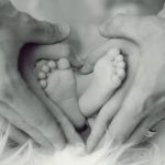 babyvoeten omvouwen door de handen van de ouders in de vorm van een hart